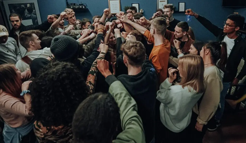 An image of a youth group putting their hands together representing Dare 2 Share's blog titled How to Implement the 7 Values of a Gospel Advancing Ministry