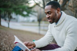An image of a man reading a book representing Dare 2 Share's blog titled 6 Essentials for Youth Leader Training.