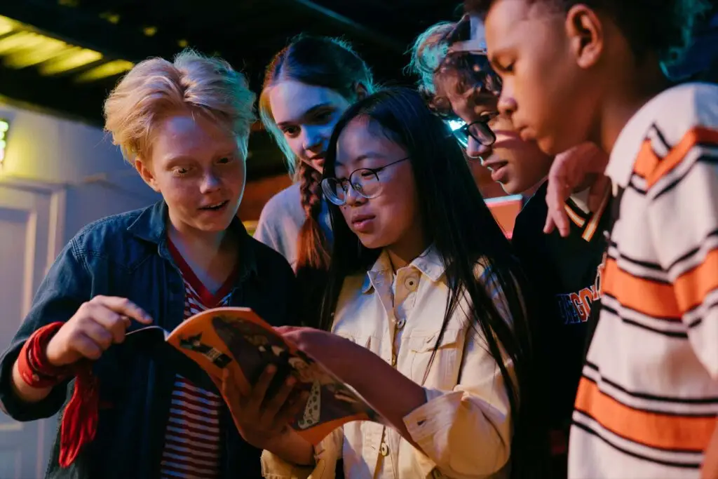 An image of students looking at a book representing Dare 2 Share's blog titled Youth Group Games With a Purpose.