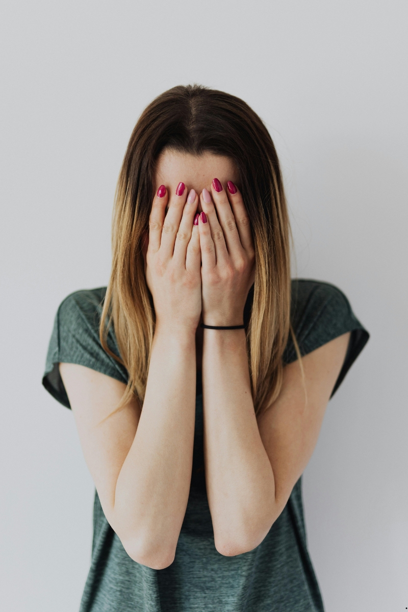Image of a teen girl with her hands over her face representing evangelism fear.