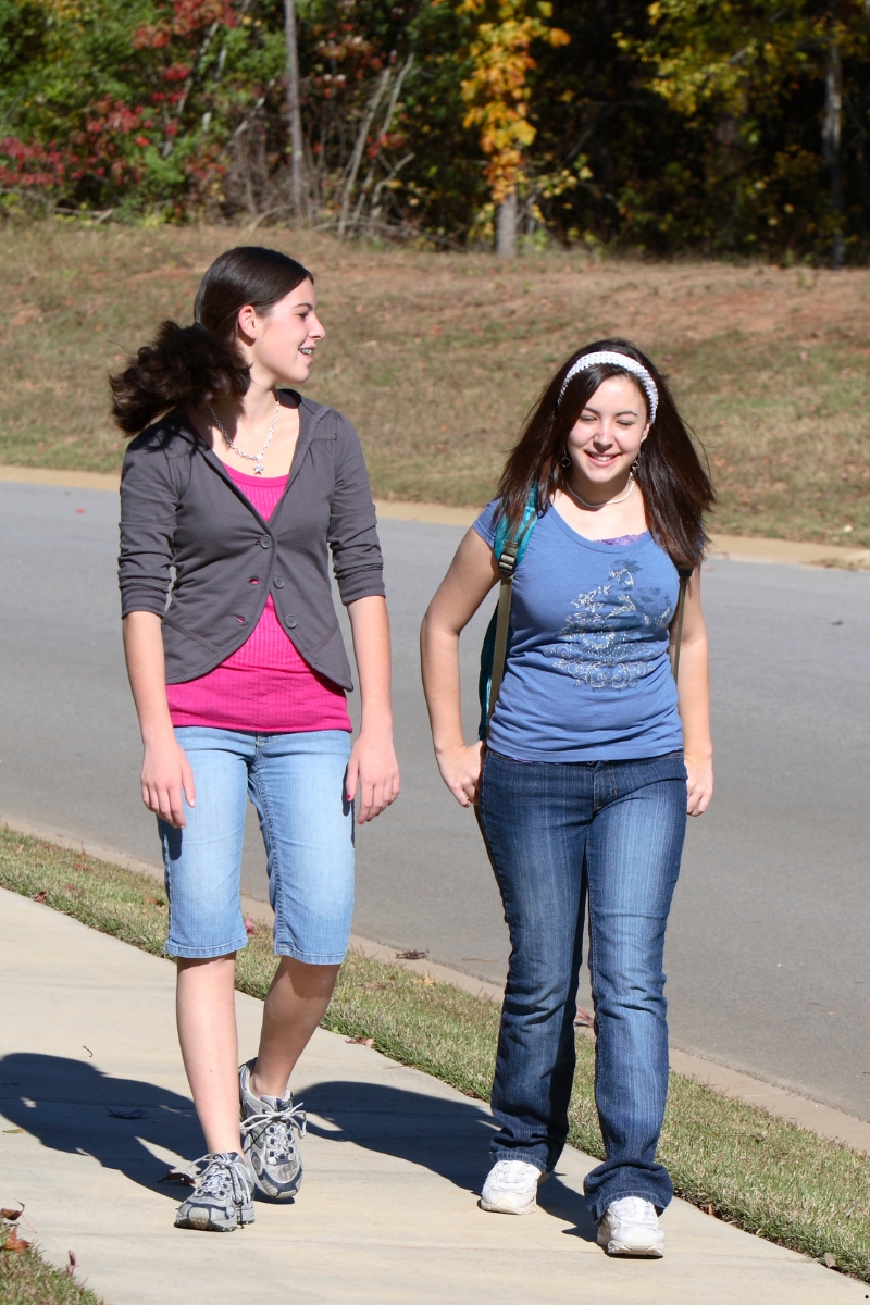 Image of two girls talking while walking home from school representing how to measure evangelism impact.